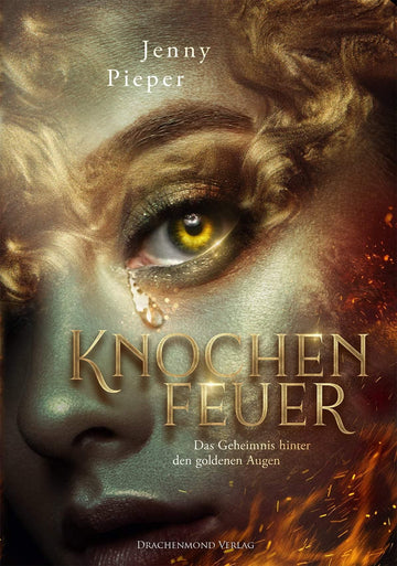Das Produktbild zeigt die Nahaufnahme eines weiblichen Gesichts. Die Frau hat goldene, glänzende Haut und gelbe Augen. Es läuft eine Träne aus dem Auge heraus. Das Gesicht ist mit goldenen Locken umrahmt. Der Titel und der Autorinnenname stehen in der unteren Hälfte des Covers. Neben dem Titel sind einige Flammen abgebildet.